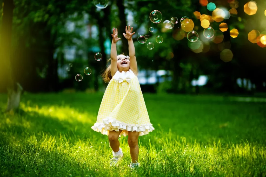 Enfant joue avec des bulles portant la tenue du collection printemps